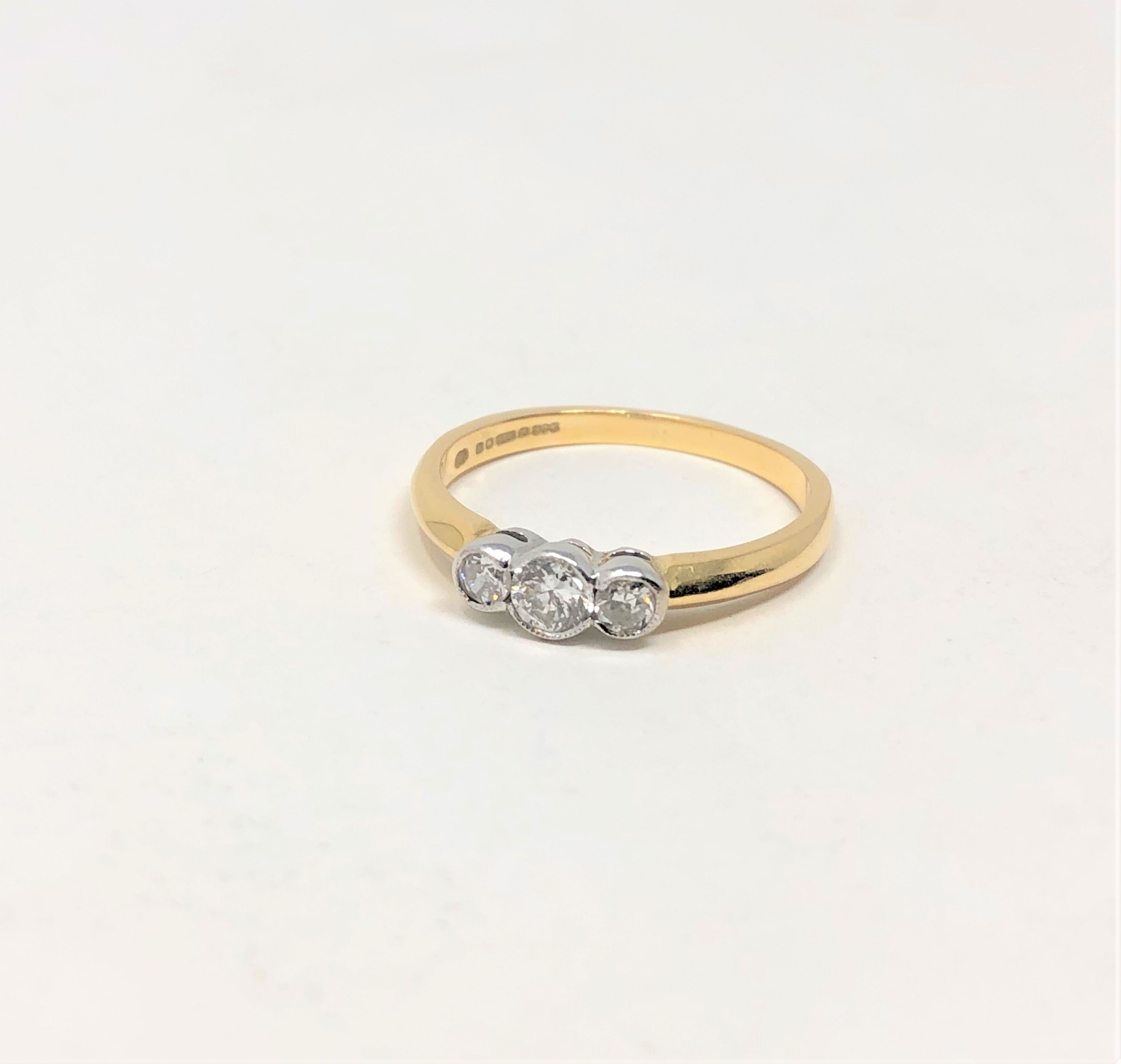 An 18ct gold three stone diamond ring, the stated total diamond weight 0.