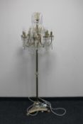 A brass eight way floor lamp with glass drops