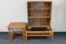 A mid twentieth century nest of three teak tables together with a teak two tier glass topped coffee