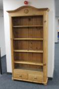 A set of pine arched topped bookshelves on bun feet