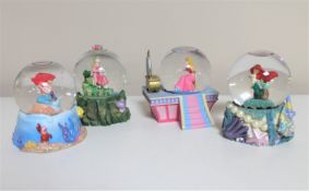 Four Disney snow globes : two Sleeping Beauty and two Little Mermaid