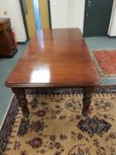 A Victorian mahogany extending dining room table fitted with a leaf, total length 216 cm.