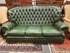 A green buttoned leather Chesterfield three seater settee,