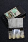 A cased three piece dressing table brush set together with a boxed plated tea service and two sets