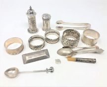 A group of silver to include sifters, spoons, sugar tongs, napkin rings, cheroot etc,