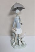 A Lladro figure - Girl with parasol feeding ducks