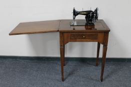 A mid twentieth century Jones electric sewing machine in mahogany table