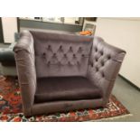 A buttoned deep sided two seater settee upholstered in mauve fabric,