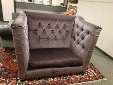 A buttoned deep sided two seater settee upholstered in mauve fabric,