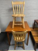A stained pine kitchen table together with a pair of striped pine kitchen chairs