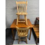 A stained pine kitchen table together with a pair of striped pine kitchen chairs