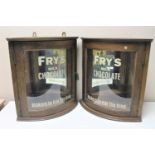 A pair of Edwardian and later oak glazed door wall cabinets with Fry's Chocolate advertising