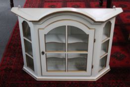A white and gilt wall cabinet