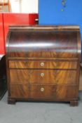 A late 19th century mahogany barrel fronted bureau