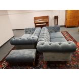 A three piece Delcor lounge suite comprising of three seater buttoned blue suede Chesterfield style