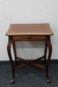 A mahogany occasional table on cabriole legs fitted with a drawer