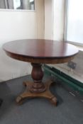 An antique oval pedestal dining table