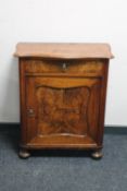 An antique continental walnut cupboard fitted with a drawer on bun feet CONDITION