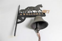 A cast iron bell on bracket - welcome