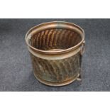 An antique hammered copper twin handled log bin