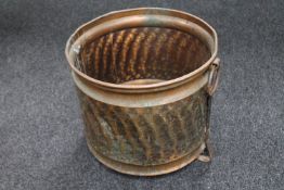 An antique hammered copper twin handled log bin