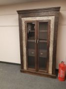 An Eastern carved hardwood glazed double door cabinet fitted with two drawers ,
