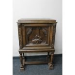 A continental oak cabinet with carved panel door on raised legs