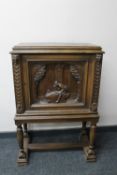 A continental oak cabinet with carved panel door on raised legs