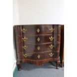 An antique serpentine fronted four drawer chest with metal handles
