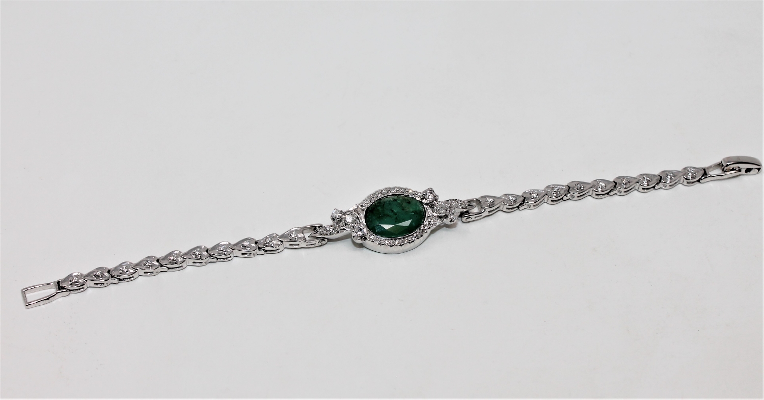 A 14ct white gold emerald and diamond bracelet, the oval-cut emerald weighing approximately 3.