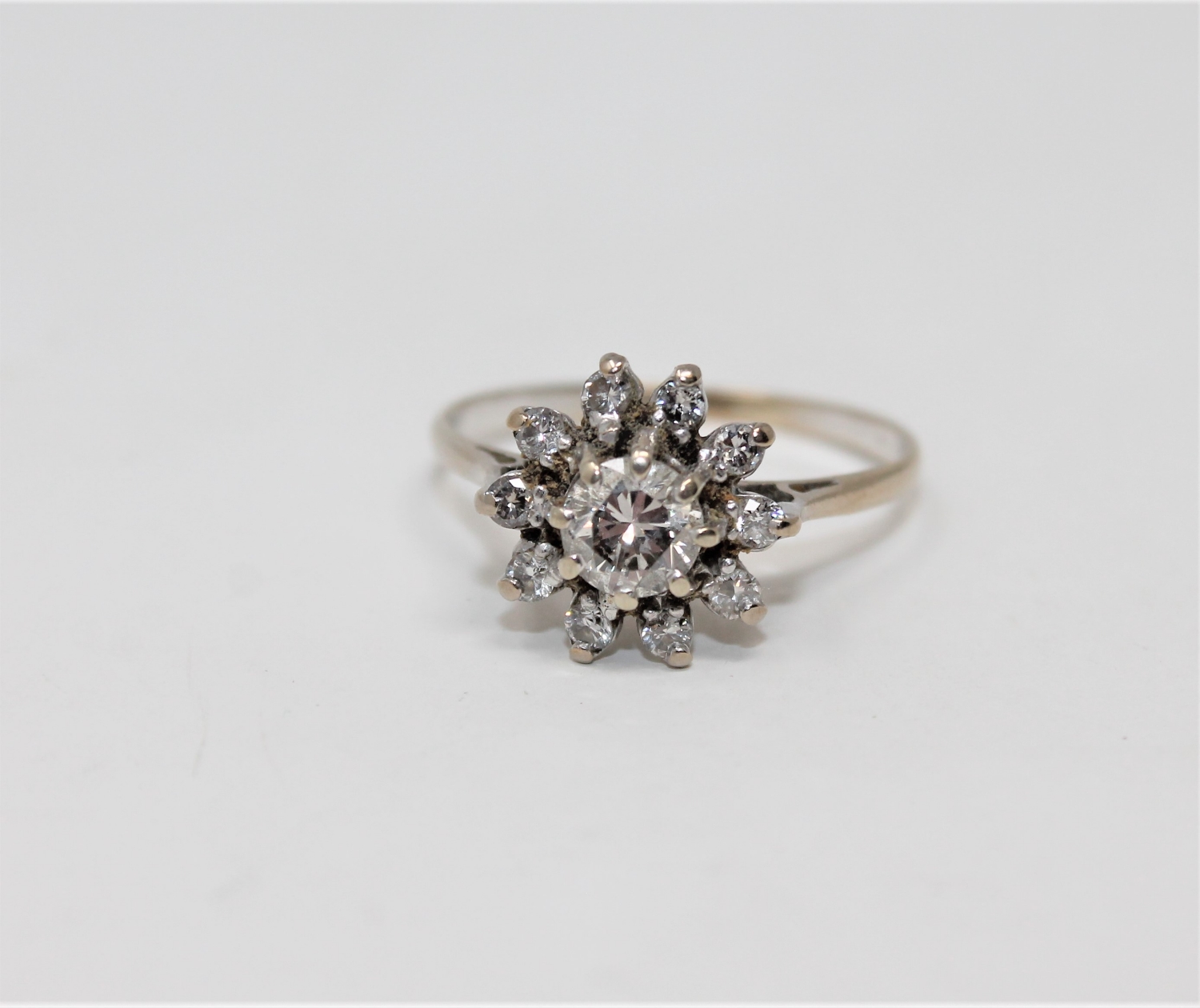 An 18ct gold diamond cluster ring, the principal brilliant-cut stone weighing approximately 0.