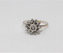 An 18ct gold diamond cluster ring, the principal brilliant-cut stone weighing approximately 0.