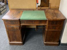 An antique mahogany twin pedestal writing desk fitted with five drawers and cupboards with green