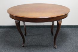 An antique mahogany oval dining table on cabriole legs