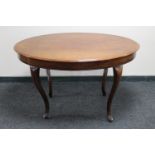 An antique mahogany oval dining table on cabriole legs