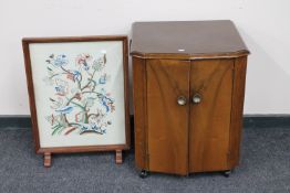 A walnut double door record cabinet together with a tapestry fire screen