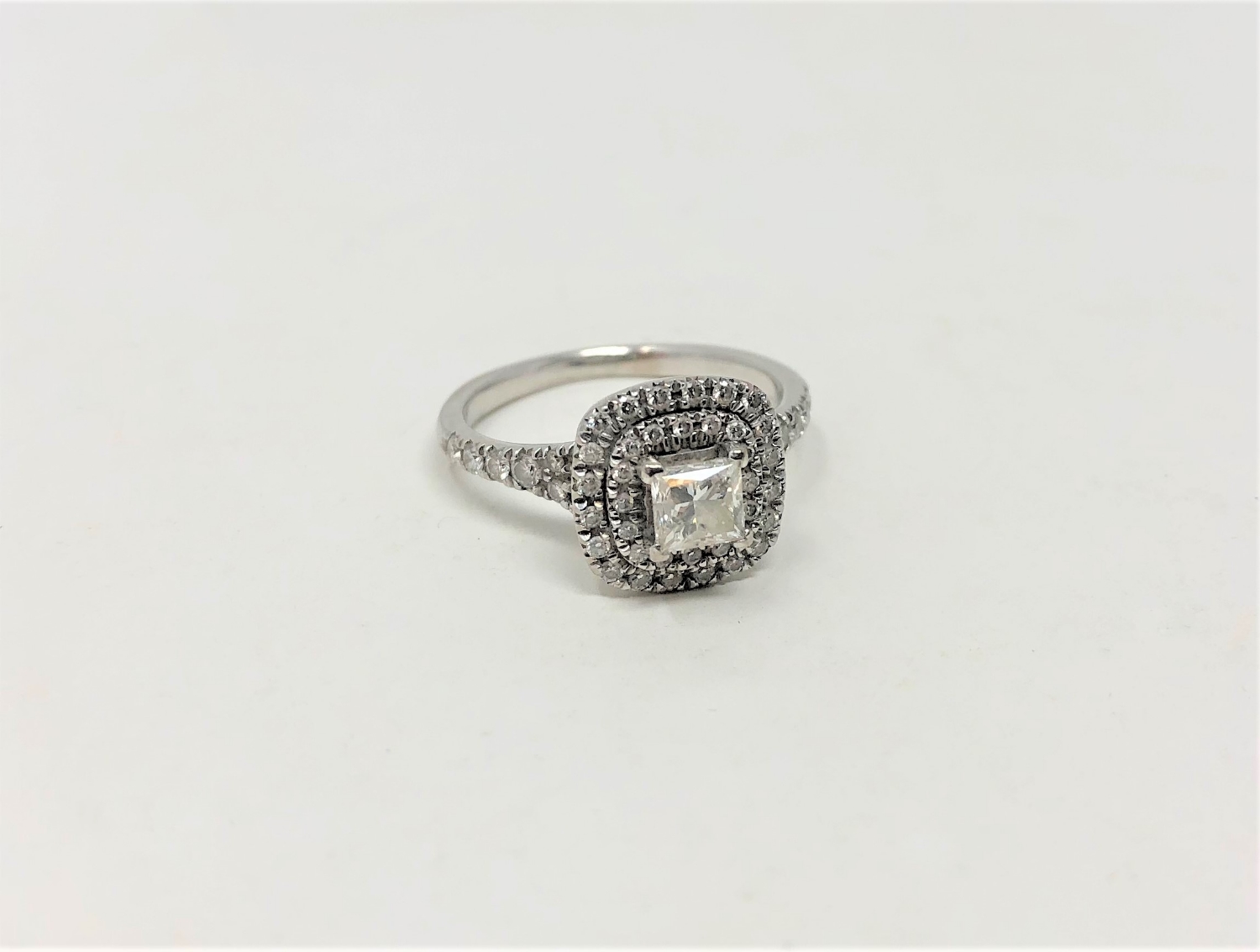 An 18ct white gold diamond cluster ring, the central princess cut stone of 0.