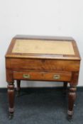 A Victorian pine clerk's desk with leather inset panel fitted with a drawer on raised legs