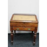 A Victorian pine clerk's desk with leather inset panel fitted with a drawer on raised legs