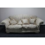 A two seater settee with loose cushions upholstered in a classical print