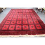 A machine made Persian style fringed carpet on red ground,