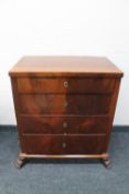 An antique mahogany four drawer chest on paw feet