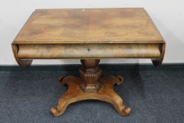 A continental mahogany library table fitted with a drawer on four-way pedestal