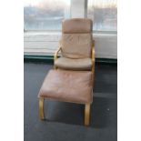 A late 20th century wood framed brown leather armchair and footstool