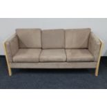 A Danish wooden framed three seater settee in suede upholstery
