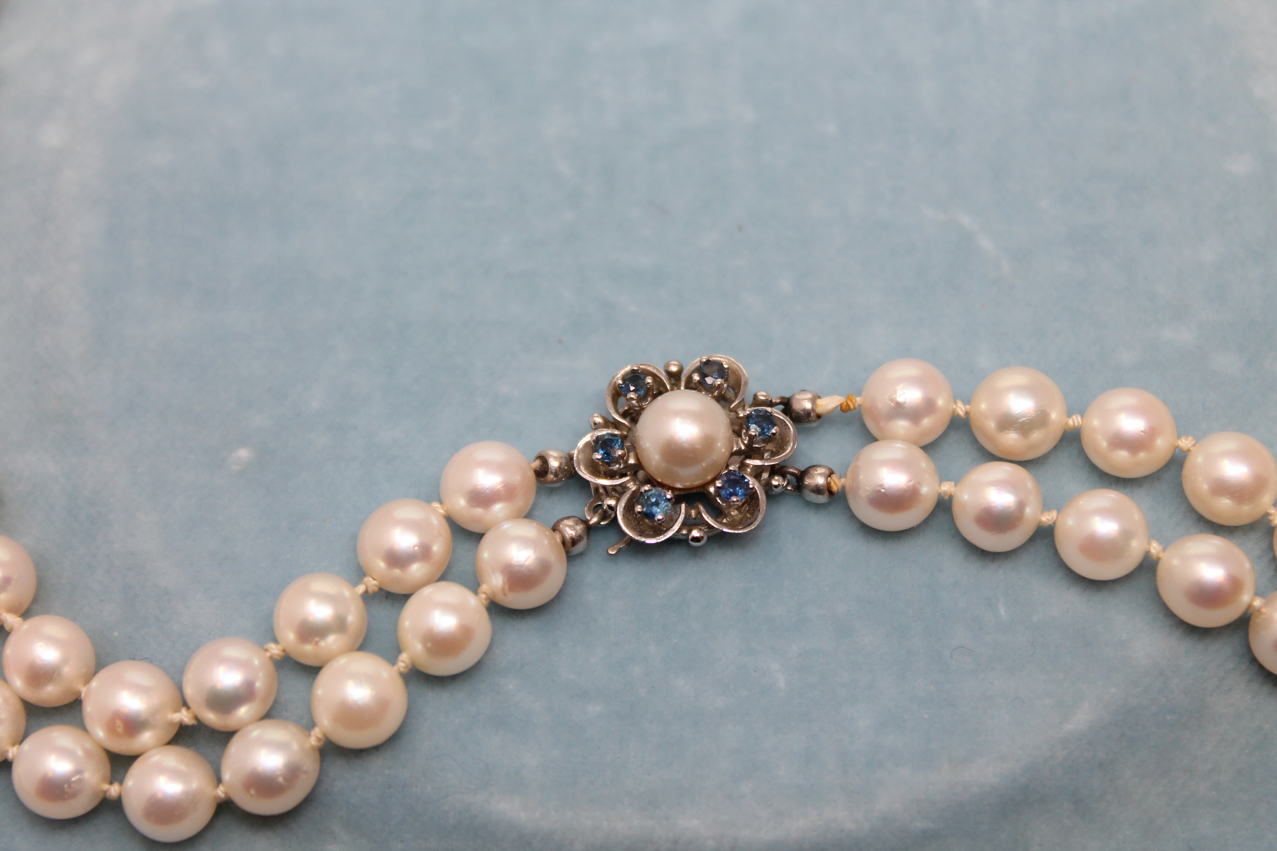 A continental two-strand cultured pearl necklace on 14ct white gold sapphire set clasp, length 44cm. - Image 2 of 2