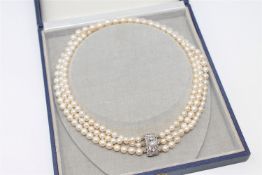 A continental triple-strand cultured pearl necklace on 14ct gold diamond and pearl set clasp,