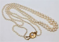 A continental two-strand cultured pearl necklace on 14ct gold pearl set clasp, length 54cm.