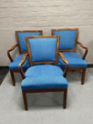 A set of three mahogany armchairs upholstered in blue fabric