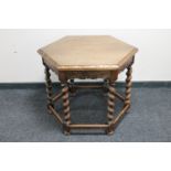 A hexagonal oak occasional table on barley twist legs